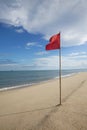 Warning sign of a red flag at a beautiful clean beach Royalty Free Stock Photo