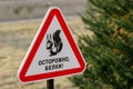 A warning sign with a red frame in the shape of a triangle with the image of a squirrel with a nut, on which the text in Russian