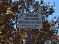 Warning sign at restricted area near Camp de Canjuers, military training ground of the French Army, with tree.