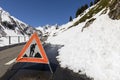 Warning sign because of a road blocked by a snow slide in the Alps
