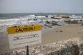 Warning sign of submerged sharp and slippery rocks