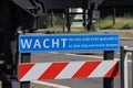 Warning sign to wait untill red light is off at rail road crossing at Waddinxveen for R-NET train