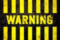 Warning sign with yellow and black stripes painted over cracked concrete wall coarse texture background Royalty Free Stock Photo