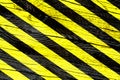 Warning sign with yellow and black stripes painted over cracked wood surface texture background Royalty Free Stock Photo