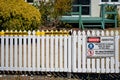 Warning signage about asbestos dust hazard outside a house