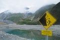 Warning signage of beware of falling rocks in New Zealand lake