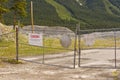 Warning signs on blocked entrance at decommissioned asbestos mine at Cassiar, BC, Canada