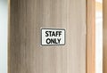 Warning silver stainless steel sign with character black message staff only in front of the wooden door Royalty Free Stock Photo