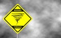 Warning tornado sign road. Yellow hazard warning sign against grey sky Royalty Free Stock Photo