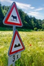 Warning traffic signs - cows cattle crossing the road and speed bumps ahead Royalty Free Stock Photo