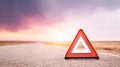 Warning triangle indicating a car breakdown or roadside emergency on an isolated road under a vivid sky, symbolizing danger or Royalty Free Stock Photo