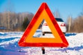 Warning triangle and white car on winter country road Royalty Free Stock Photo