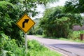 Warning turn right traffic sign in the countryside is surrounded by green trees