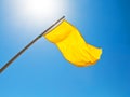 Warning yellow flag under sun with blue sky Royalty Free Stock Photo