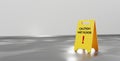 Warning yellow sign with caution wet floor inscription stand on grey tile floor on background white wall in hallway
