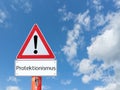 Warnsign protectionism on blue background in german