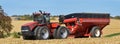 CASE IH 470 Steiger tractor pulling a fully loaded Brent Avalanche 1396 grain cart with farm scene in the background