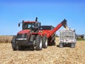 CASE IH 470 Steiger tractor pulling a fully loaded Brent Avalanche 1396 grain cart unloading into a semi for transport Royalty Free Stock Photo