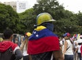 A warrior against Nicolas Maduro government ready to protest wearing anti tear gas mask and Venezuelan flag