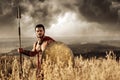 Warrior with bare torso standing among field. Royalty Free Stock Photo