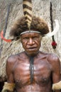 The warrior of a Papuan tribe in traditional clothes and coloring in New Guinea Island