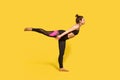 Warrior 3 pose. Slim woman with hair bun in tight sportswear practicing yoga, doing Virabhadrasana Royalty Free Stock Photo