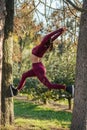 Warrior pose between trees. Beautiful girl in sportswear doing yoga on the alley in the autumn park Royalty Free Stock Photo