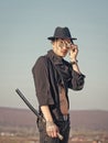 Warrior in sunglasses, black hat, tattooed torso in open clothes