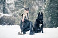 Warrior woman in image of viking with ax and horned helmet next to the dog in winter forest Royalty Free Stock Photo