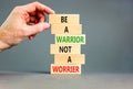 Warrior or worrier symbol. Concept words Be a warrior not a worrier on wooden blocks on a beautiful grey table grey background.