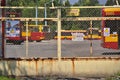 Warsaw city bus depot old rusty fence yellow red buses parked in a row in parking spaces Royalty Free Stock Photo