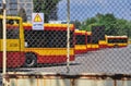 Warsaw city bus depot old rusty fence yellow red buses parked in a row in parking spaces Royalty Free Stock Photo