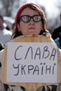 Woman holding banner at demonstration Stand with Ukraine