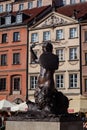 Warsaw mermaid and the facade of the historical buildings in old town market square, Warsaw, Poland