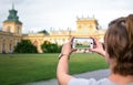 WARSAW, POLAND - AUGUST 11: A young woman photographing the royal Wilanow Palace in Warsaw