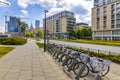 Warsaw, Poland - City bikes parking rental station at ulica Prosta street in Wola business district with Warsaw city center in