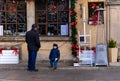 Man and child in front of closed restaurant