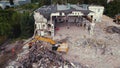 06.08.2022 - Warsaw, Poland - The excavator crusher taking down a huge old building, working on the demolition site.