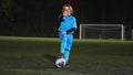 12.04.2023. Warsaw, Poland. full shot of a little footb all player girl posing with a ball on a stadium at night