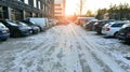 Warsaw, Poland. 8 January 2024. Cars parked in the snow covered parking lot in front of building on a sunny winter day.