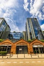 Tall glass corporate buildings facing a small brick arcade of small shops Royalty Free Stock Photo