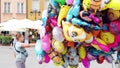 WARSAW, POLAND - JUNE 10, 2017. Female street vendor sells multiple cartoon character helium balloons