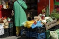 A silhouette of a client visible from the back, surrounded by vegetables, fruit and preserves on sale.