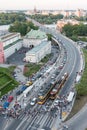 Queues of cars form as more than a hundred people exit trams and cross the road at the Stare Miasto tram stop near Castle Square