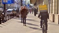 Warsaw, Poland. 8 March 2023. Crowd of people walking down an urban sidewalk