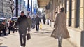 Warsaw, Poland. 8 March 2023. Crowd of people walking down an urban sidewalk