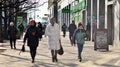 Warsaw, Poland. 8 March 2023. Crowd of people walking down an urban sidewalk