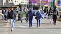 Warsaw, Poland. 8 March 2023. Crowd of people walking down an urban sidewalk