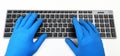 Warsaw, Poland - March 21, 2020:Dell Premier KM717 Black / Gray BT.A man in bright yellow rubber gloves is typing on the keyboard.