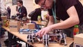 WARSAW, POLAND - MARCH, 4, 2017. Young nerdy man repairing DIY hexapod robot